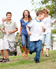 Image showing Family chasing young kid in the park