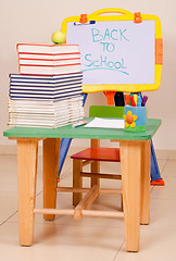 Image showing School books and apple on desk with sketchboard