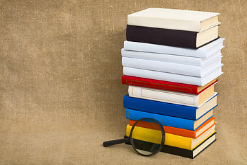 Image showing Big pile of books and magnifier glass