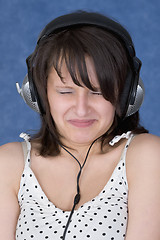 Image showing Lady make a wry face in earphones