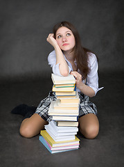 Image showing Girl sits having leant the elbows on a books