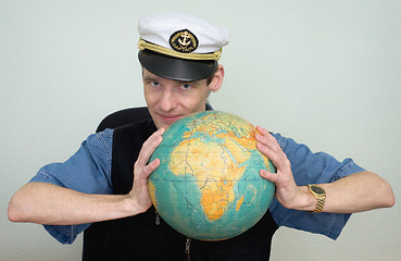 Image showing Guy in a sea uniform cap with globe