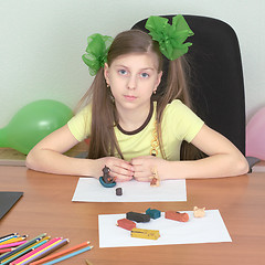 Image showing Girl sitting at a table with plasticine