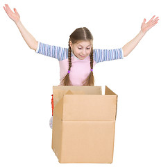 Image showing Little girl joyfully looks in a box