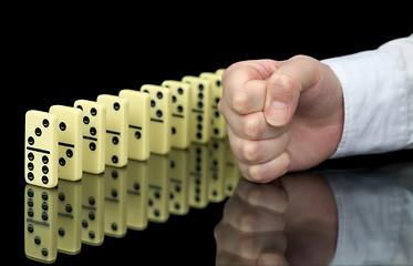 Image showing Fist a provoking domino effect