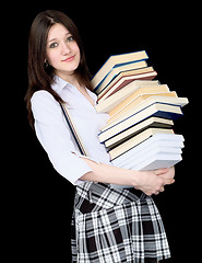 Image showing Girl with a pile of books in hands on black