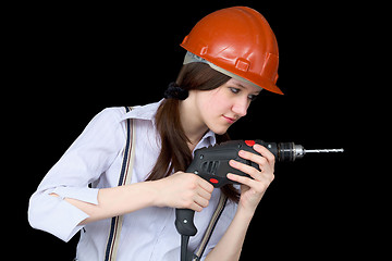 Image showing Young woman in a protective helmet with a drill