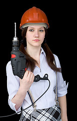Image showing Beautiful girl in a protective helmet with a drill