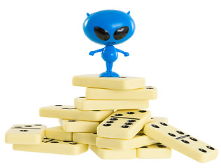 Image showing Blue toy alien on a heap from dominoes