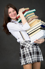 Image showing Schoolgirl bearing pile of books