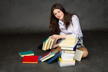 Image showing Schoolgirl with the big heap of books