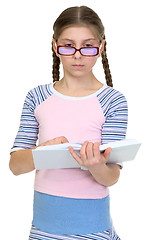 Image showing Serious schoolgirl with spectacles and book