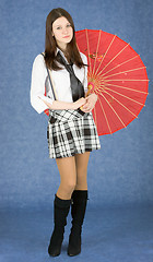 Image showing Girl with red umbrella on a blue background
