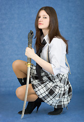 Image showing Girl with sword sit on a blue background