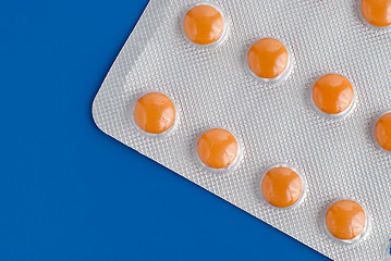 Image showing Close-up of a pack of orange pills 