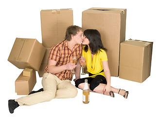 Image showing Girl and the guy drink champagne near boxes