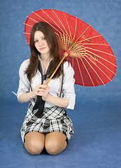 Image showing Beautiful girl sits with the Japanese umbrella