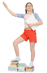 Image showing Girl standing on piles of books