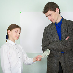 Image showing Girl stretches money to the guy