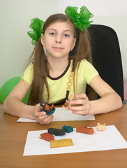 Image showing Girl sitting at a table with plasticine