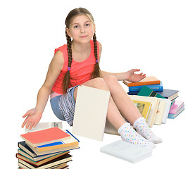 Image showing Schoolgirl among a heap of books