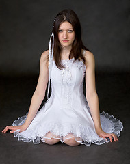 Image showing Girl in white dress sits on a black