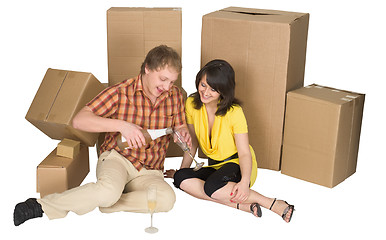 Image showing Girl and the guy drink champagne near boxes