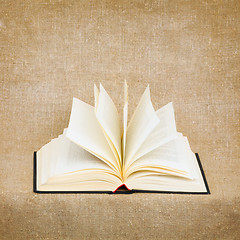 Image showing Open old book on brown canvas background