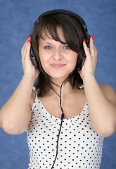 Image showing Girl in ear-phones on a blue background