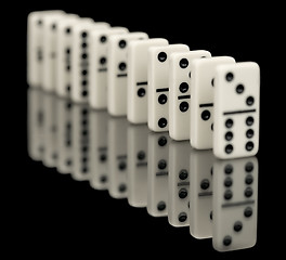 Image showing Some bones of dominoes put abreast on a black