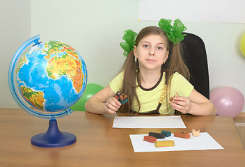 Image showing Girl sitting at a table with plasticine