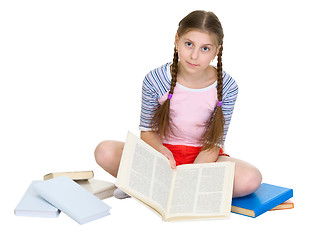 Image showing Schoolgirl sitting with a heap of books