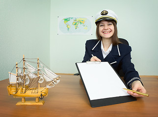Image showing Woman in a sea uniform sitting at a table with a tablet