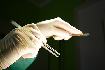 Image showing Hand with tweezers and sclapel