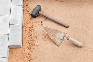 Image showing Tools of the mason on a sand - trowel and hammer