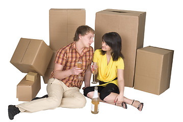 Image showing Girl and the guy drink champagne near boxes