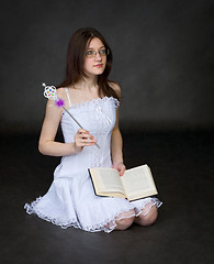 Image showing Girl - the magician with the book sits on black