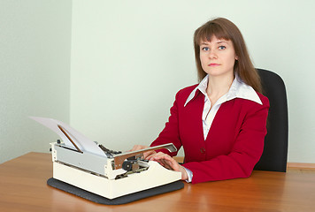 Image showing Young girl at office with a typewriter