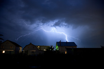 Image showing Lightning in the cloudy sky over village