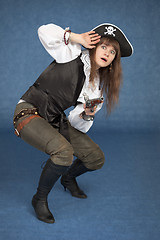 Image showing Frightened pirate girl - with pistol on a blue