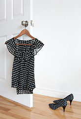 Image showing Polka dot blouse on a hanger and shoes on the floor