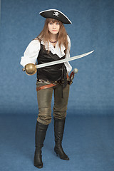 Image showing Sexyl woman - pirate armed with a sabre on blue background