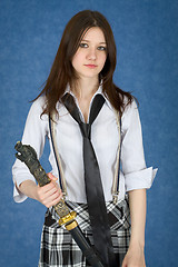 Image showing Beautiful girl standing on blue background with japanese sword