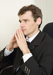 Image showing Guy in black jacket sits having combined hands