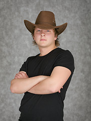 Image showing Beautiful serious young man in cowboy hat on grey background