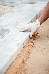 Image showing Installation of brick platform - laying bricks on sand