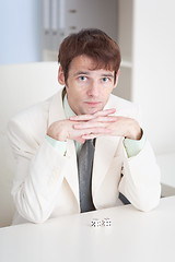 Image showing Young businessman sits at office on workplace