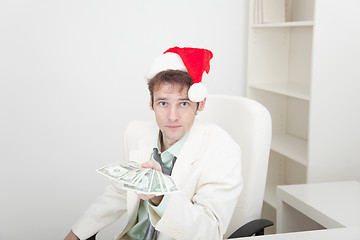 Image showing Guy in Christmas hat gives us money