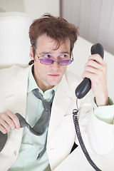 Image showing Businessman emotionally speaks on phone at office