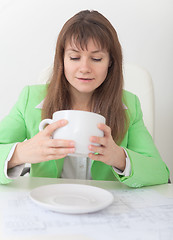 Image showing Woman looks in huge cup for coffee